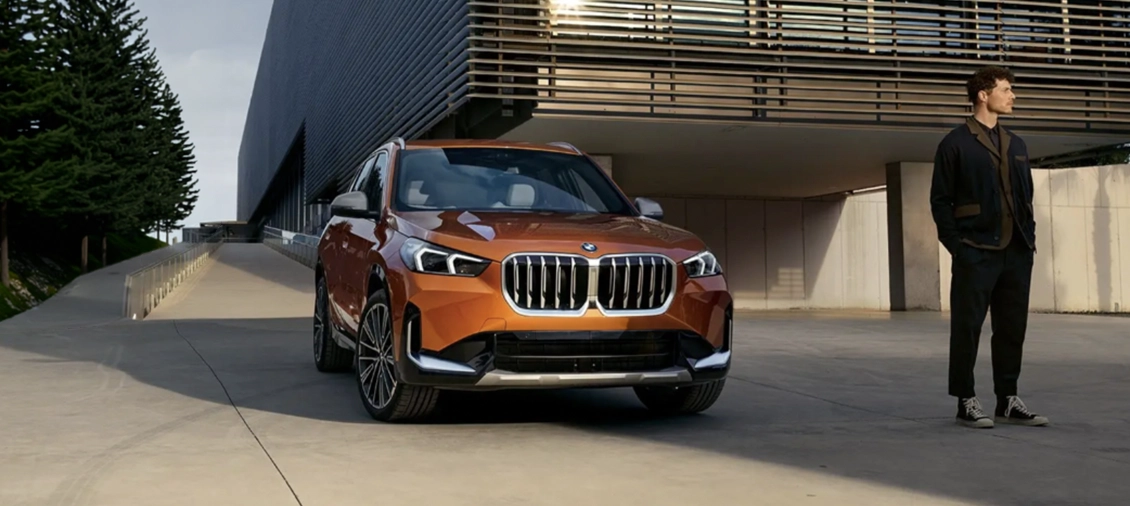 Man standing next to a modern BMW SUV highlighting the Canadian Forces military incentive and discount program