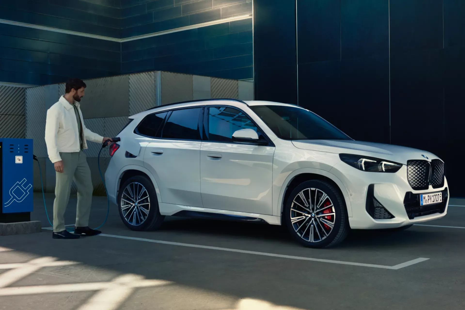 Branchement d'un câble de recharge sur un véhicule électrique BMW.