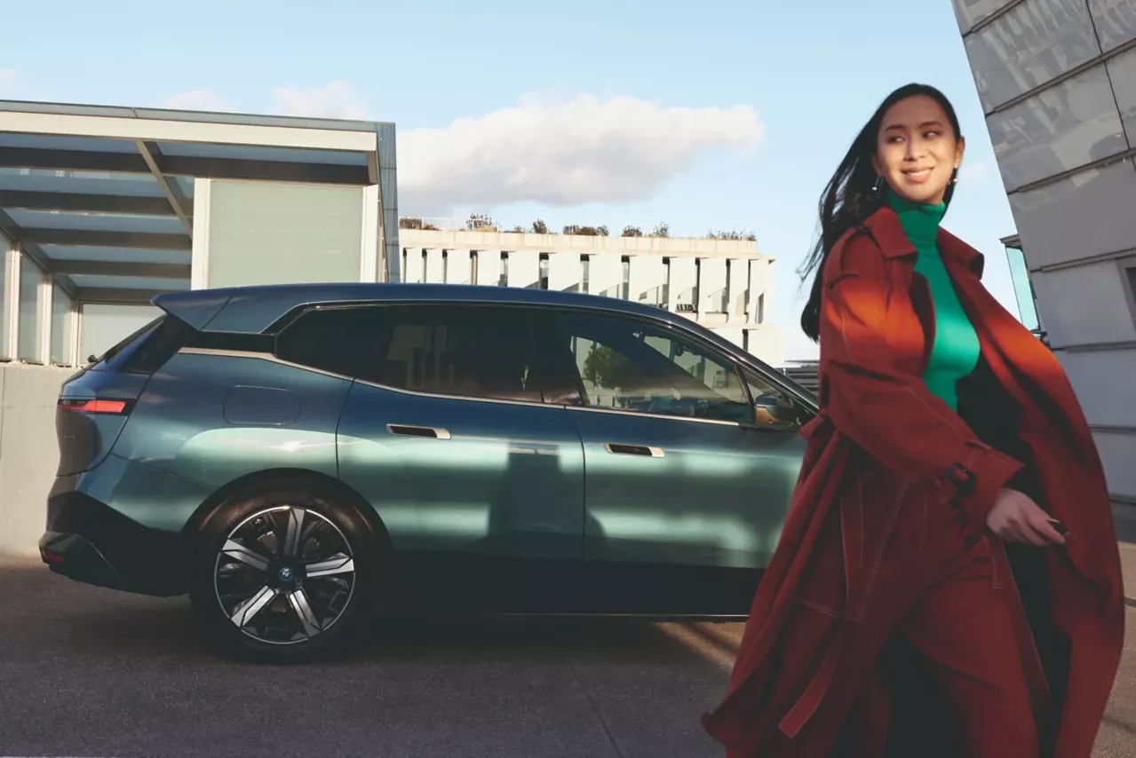 Professionnel s'éloignant d'une BMW stationnée après un entretien de service.