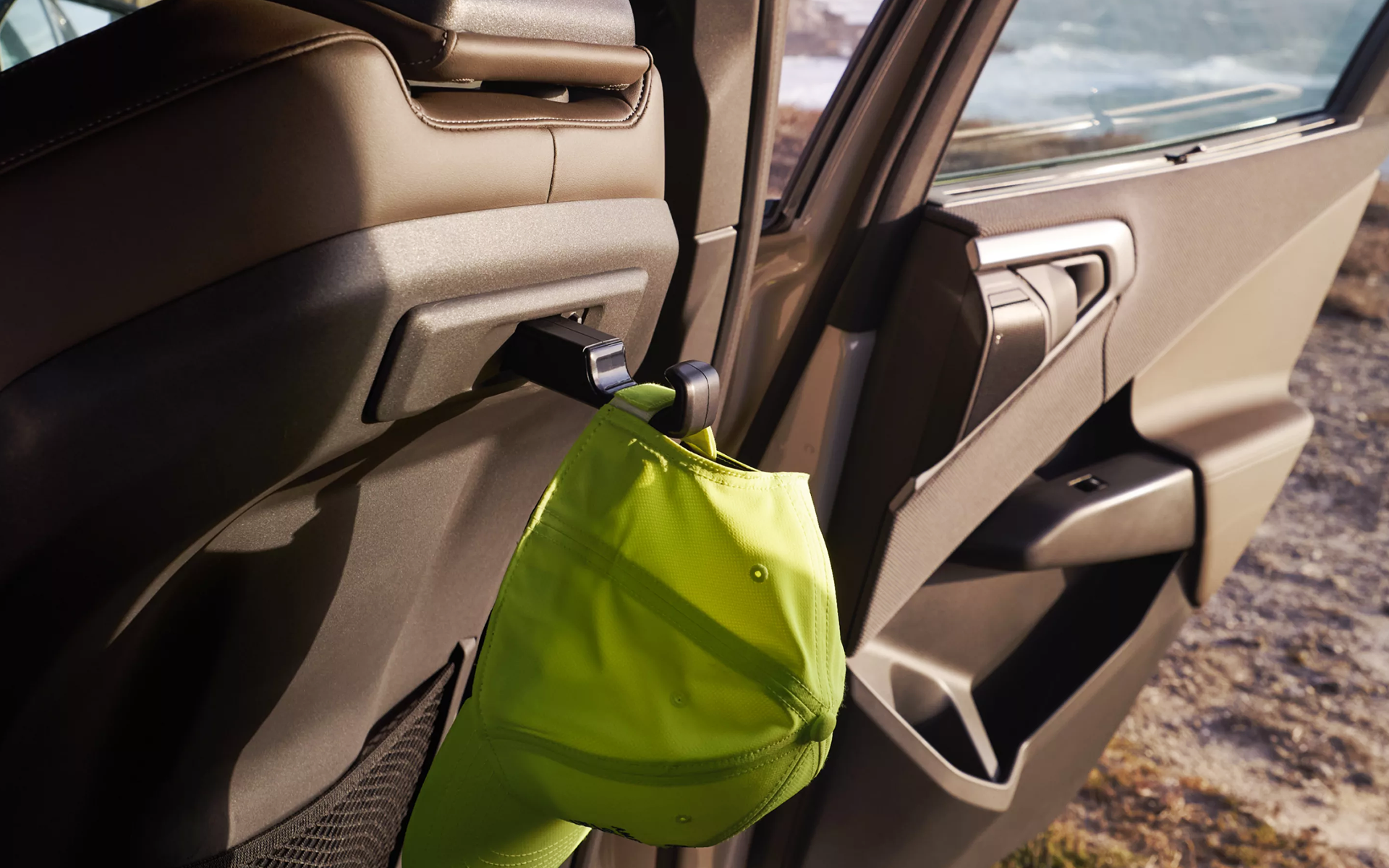 Neon cap hanging on an accessory hook behind a BMW seat.