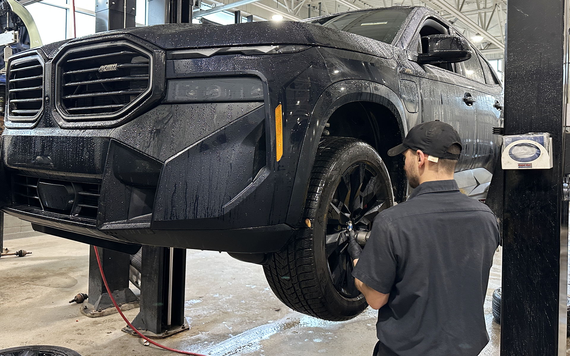 Technicien effectuant l’entretien d’un VUS BMW dans l’atelier de BMW Sainte-Agathe