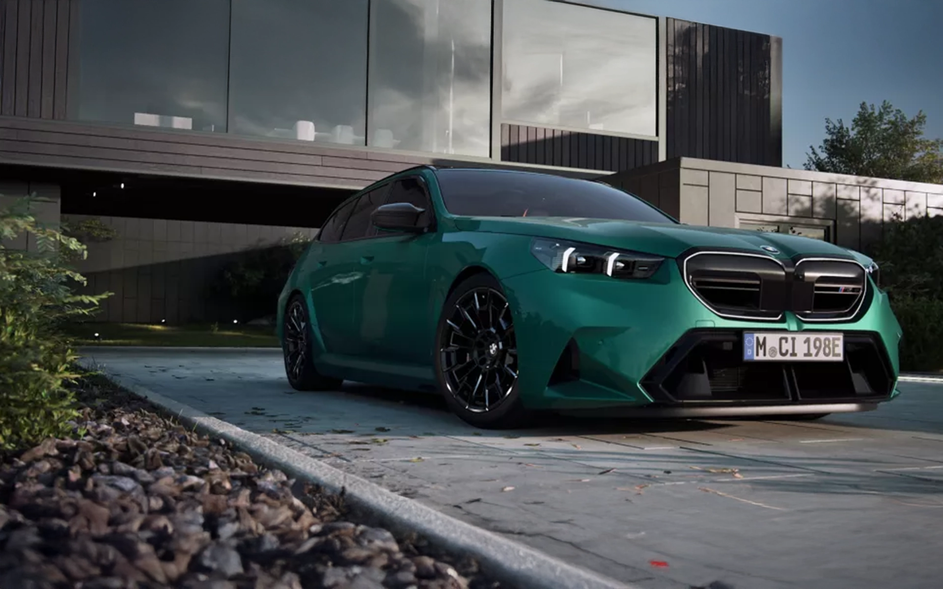 2025 BMW M5 Touring in green parked in front of a modern home – available at BMW Ste-Agathe.