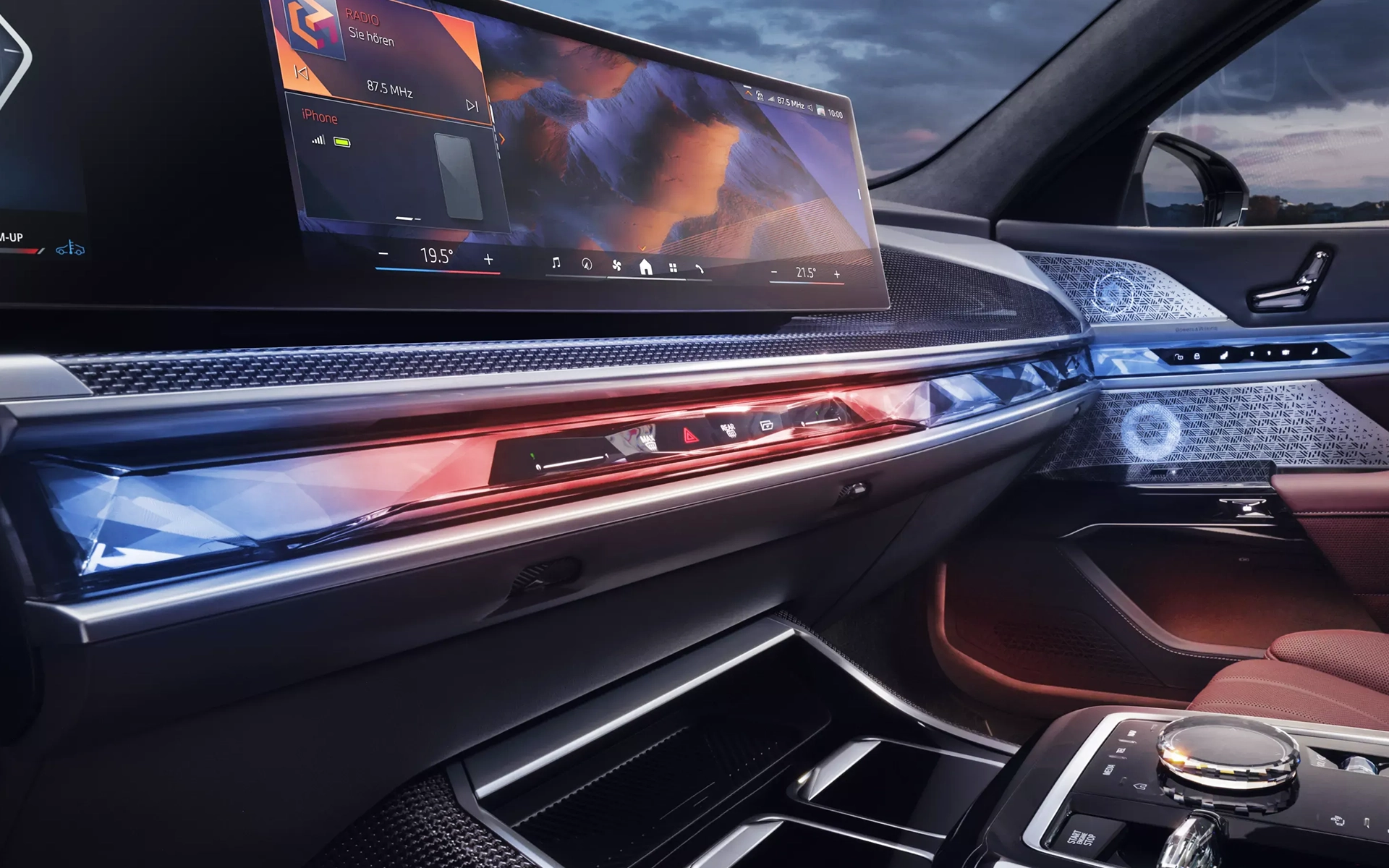 BMW dashboard with digital display and ambient red and blue lighting, showing multimedia information.