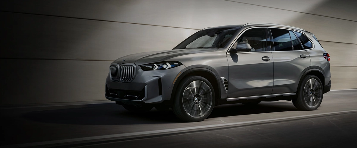 2025 BMW X5 on highway, silver color, demonstrating speed and elegance.