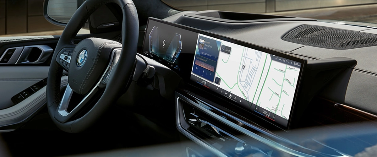 Driver's dashboard view inside 2025 BMW X5, showing high-tech display and controls.