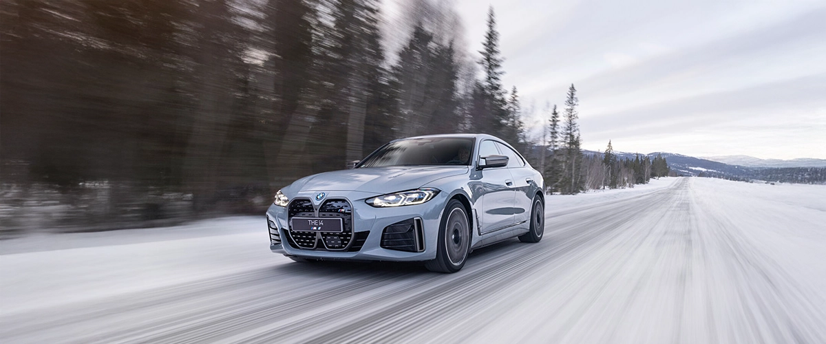 BMW i4, snowy road, xDrive technology, electric car, winter driving.