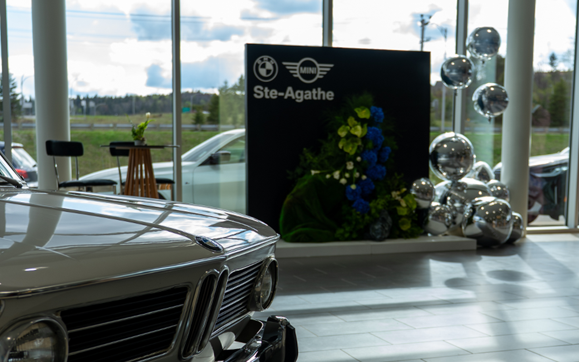 Floral display inside BMW – MINI Ste-Agathe, featuring the dealership's logo.