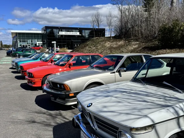 Rangée de BMW de collection devant la concession, BMW 2002 blanche au premier plan.