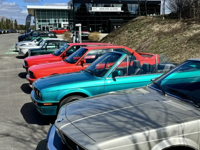 BMW Série 6 argentée et cabriolet BMW turquoise dans une rangée de véhicules de collection.