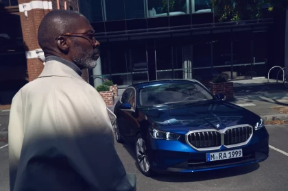Image of Client d'affaires marchant vers sa BMW dans un stationnement extérieur.
